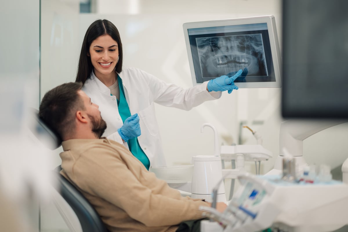 Female dentist showing a teeth x-ray to a patient in a dental clinic