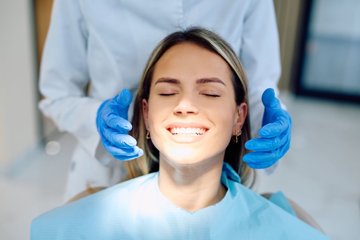 Happy patient with white teeth receiving dental examination from dentist, showcasing successful cosmetic dentistry and oral health